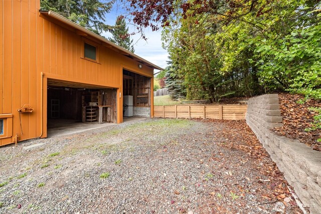 view of property exterior featuring fence, an outbuilding, board and batten siding, a pole building, and a garage