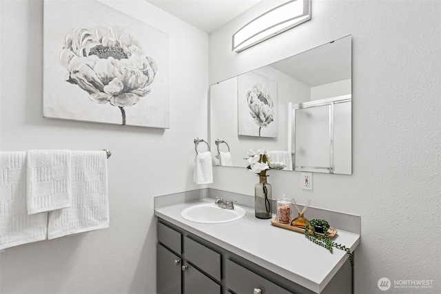 full bathroom with vanity and a shower stall