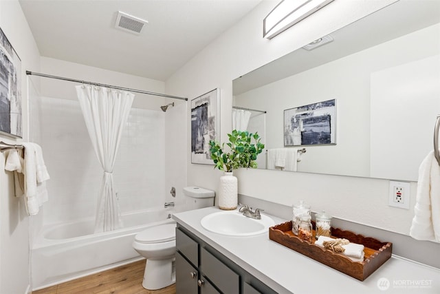 bathroom featuring visible vents, wood finished floors, vanity, toilet, and shower / tub combo with curtain