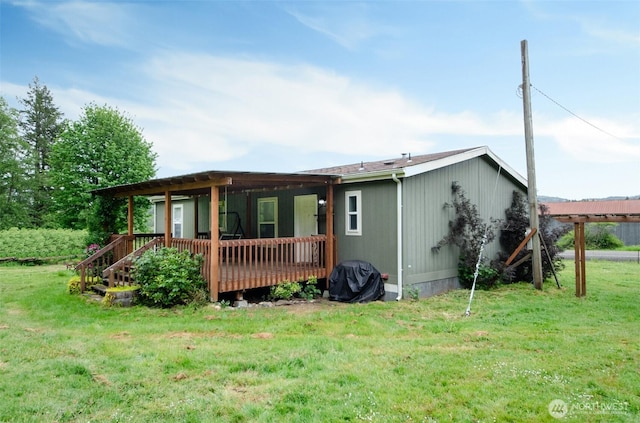 view of front of property with a deck and a front lawn