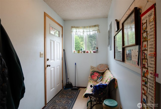 entryway with a textured ceiling and carpet flooring