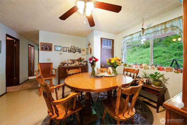 carpeted dining area with a textured ceiling and a ceiling fan