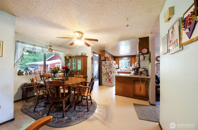 dining area with a textured ceiling and a ceiling fan