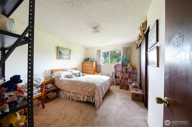 bedroom with light carpet and a textured ceiling