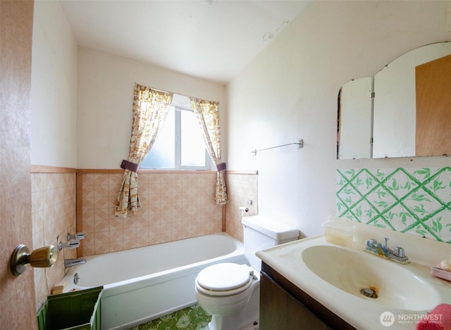 bathroom with toilet, a tub to relax in, and vanity