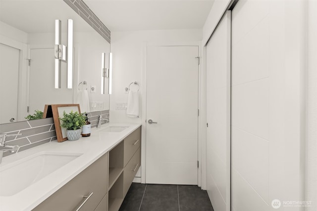 bathroom featuring tile patterned floors, a sink, and double vanity