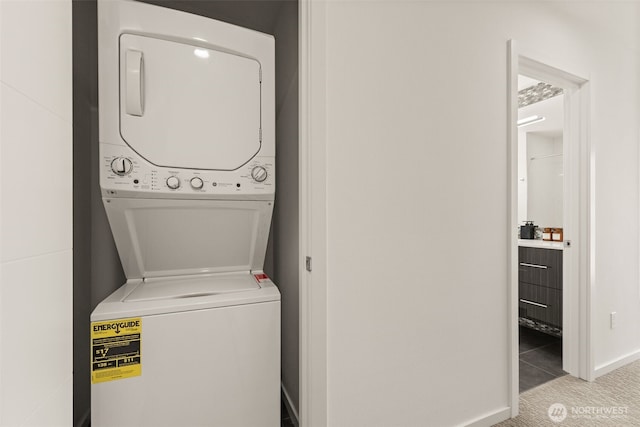 washroom with stacked washer and dryer and laundry area