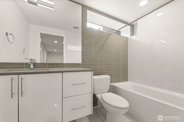 full bath featuring shower / bathing tub combination, vanity, tile walls, toilet, and visible vents