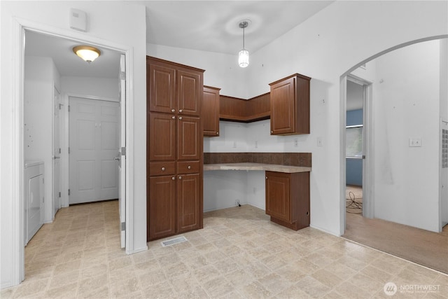 23914 66th St E Unit 33, Buckley, WA 98391 - kitchen featuring arched walkways, washer / dryer, and hanging light fixtures