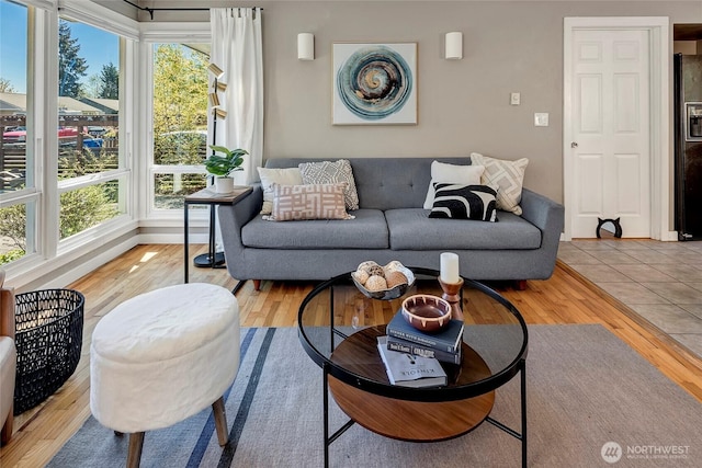 living area with baseboards and wood finished floors