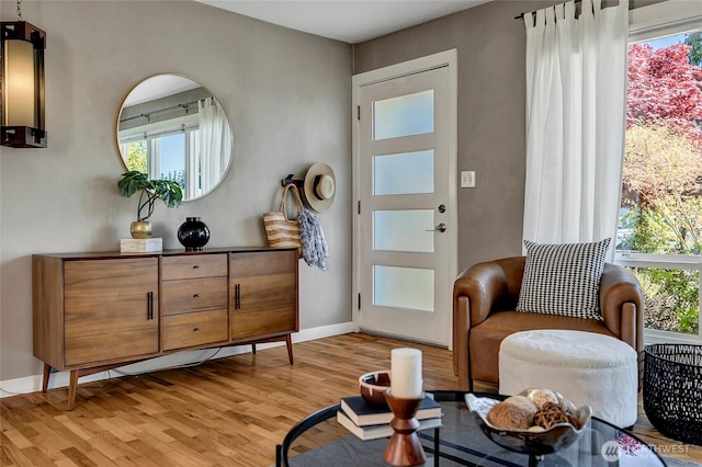 living area with baseboards and light wood-style floors