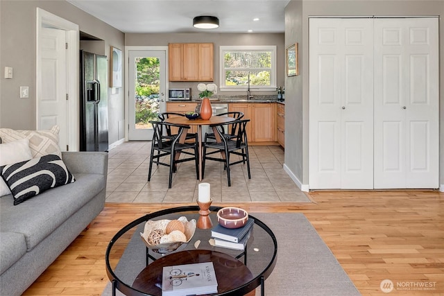 living room featuring light wood-type flooring, baseboards, and recessed lighting