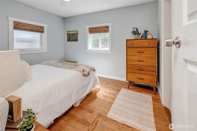 bedroom with baseboards, a ceiling fan, multiple windows, and light wood-type flooring