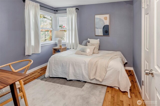 bedroom featuring wood finished floors and baseboards