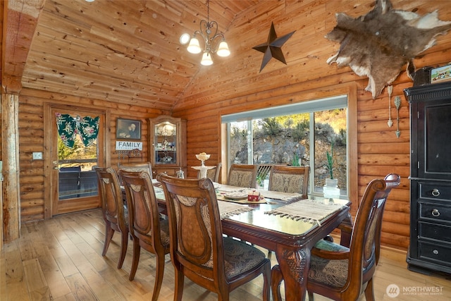 dining space with vaulted ceiling, wood ceiling, light wood finished floors, a notable chandelier, and log walls