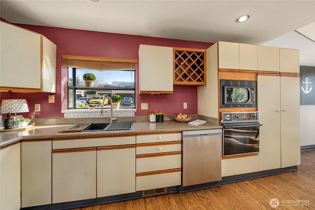5201 Hyada Blvd NE, Tacoma, WA 98422 - kitchen featuring a sink, black appliances, light wood-type flooring, cream cabinets, and recessed lighting