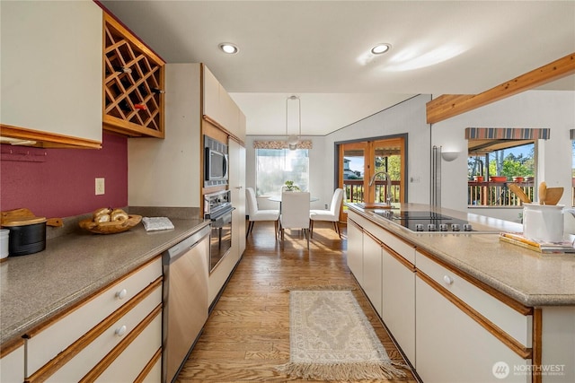 5201 Hyada Blvd NE, Tacoma, WA 98422 - kitchen with light wood finished floors, white cabinets, recessed lighting, decorative light fixtures, and black appliances