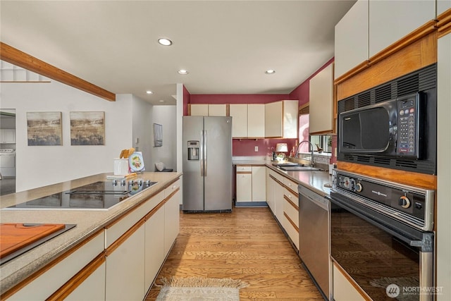 5201 Hyada Blvd NE, Tacoma, WA 98422 - kitchen with a sink, black appliances, light wood-style flooring, washer / clothes dryer, and recessed lighting