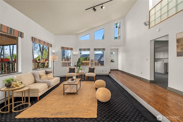 5201 Hyada Blvd NE, Tacoma, WA 98422 - living area featuring wood finished floors, a high ceiling, track lighting, washing machine and dryer, and baseboards