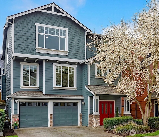 craftsman-style home with a garage, concrete driveway, and stone siding