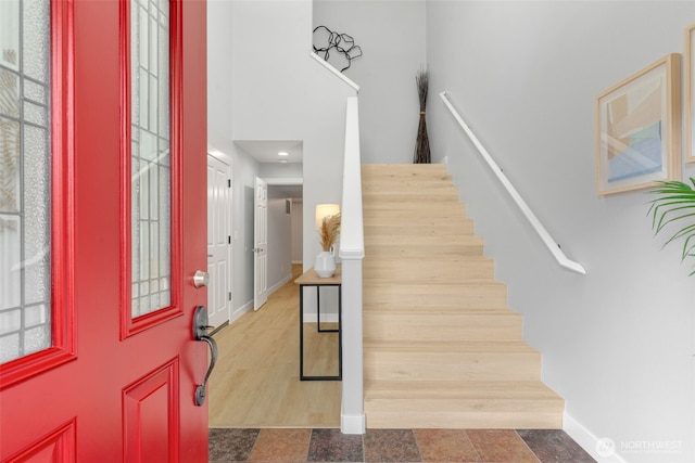 entrance foyer featuring a high ceiling, stairway, and baseboards