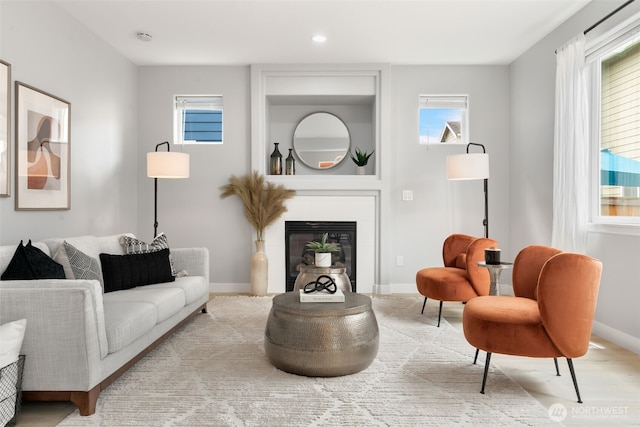 living area featuring healthy amount of natural light, baseboards, a fireplace, and recessed lighting