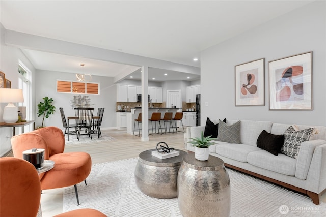 living area with light wood-type flooring and recessed lighting