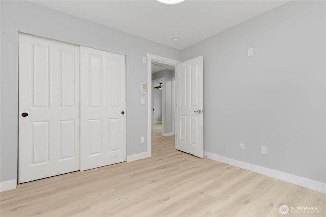 unfurnished bedroom with light wood-type flooring, baseboards, and a closet
