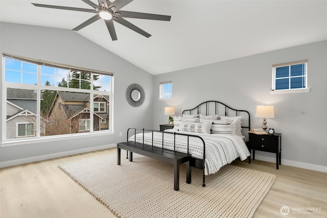 bedroom with light wood-style floors, baseboards, lofted ceiling, and a ceiling fan