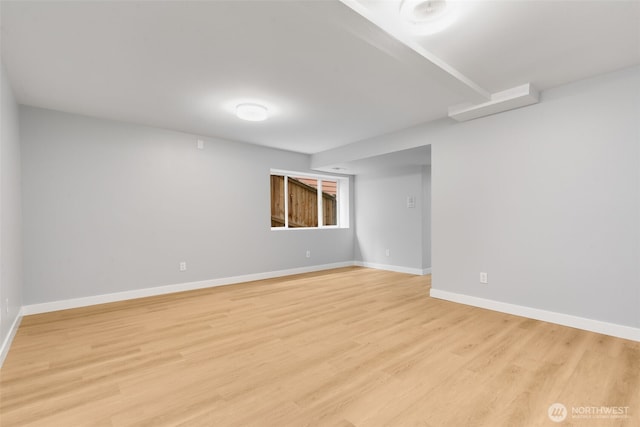 finished below grade area with light wood-style flooring and baseboards