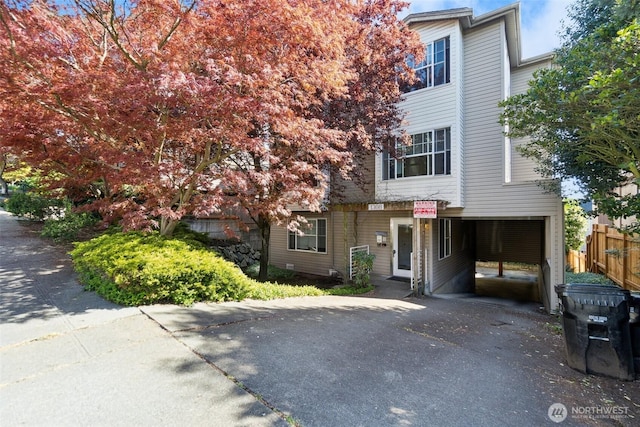 view of front of house with aphalt driveway and fence