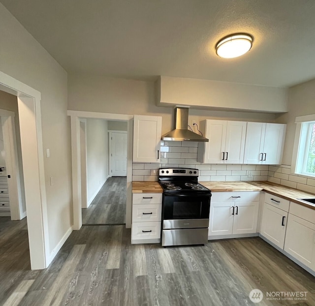 kitchen with butcher block counters, stainless steel electric range, backsplash, and wall chimney range hood