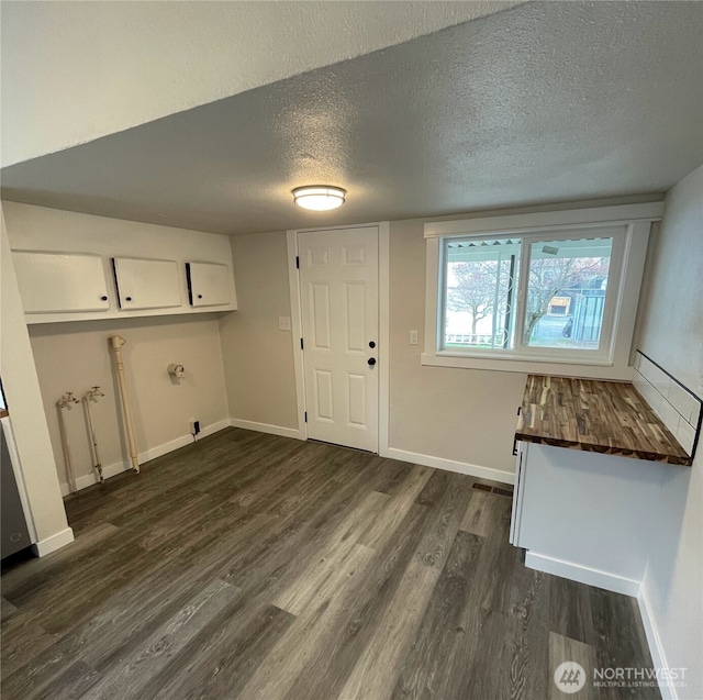 entrance foyer with baseboards, a textured ceiling, and dark wood finished floors
