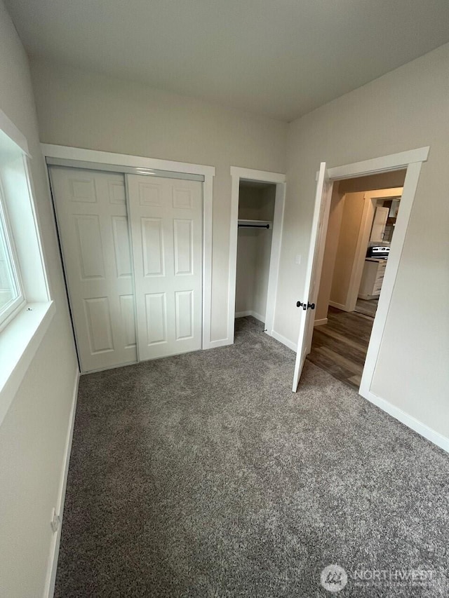 unfurnished bedroom featuring multiple closets, baseboards, and carpet