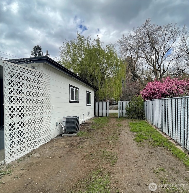 view of property exterior featuring central AC and fence