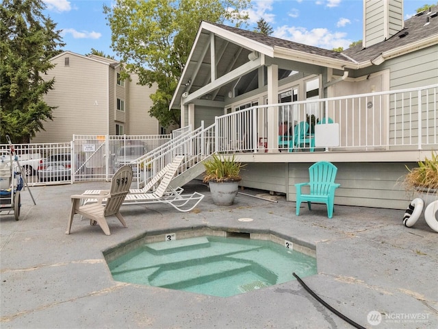 975 Aberdeen Ave NE Unit E103, Renton, WA 98056 - rear view of house featuring a patio, a chimney, fence, an in ground hot tub, and roof with shingles
