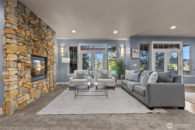 carpeted living room with french doors, healthy amount of natural light, a fireplace, recessed lighting, and baseboards