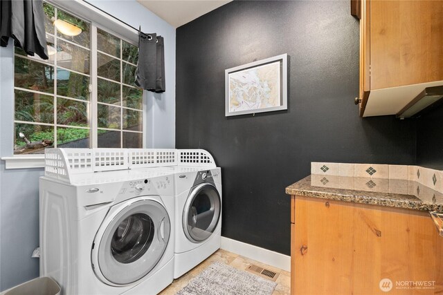 clothes washing area featuring cabinet space, separate washer and dryer, and baseboards