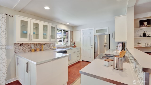 19134 SE May Valley Rd, Issaquah, WA 98027 - kitchen with stainless steel fridge, a peninsula, a sink, recessed lighting, and wood finished floors