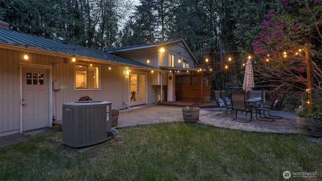 19134 SE May Valley Rd, Issaquah, WA 98027 - rear view of property featuring central AC unit, a patio, metal roof, and a lawn