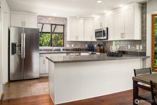 26032 5th Ave NE, Arlington, WA 98223 - kitchen featuring stainless steel appliances, a peninsula, white cabinetry, decorative backsplash, and recessed lighting