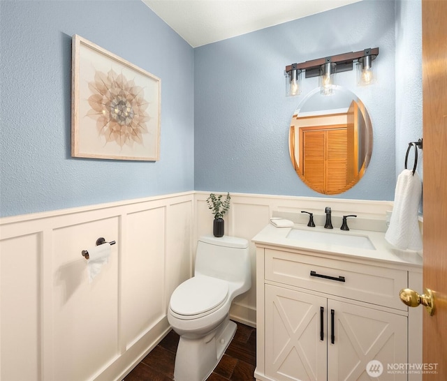 26032 5th Ave NE, Arlington, WA 98223 - bathroom featuring vanity, a wainscoted wall, a decorative wall, and wood finished floors