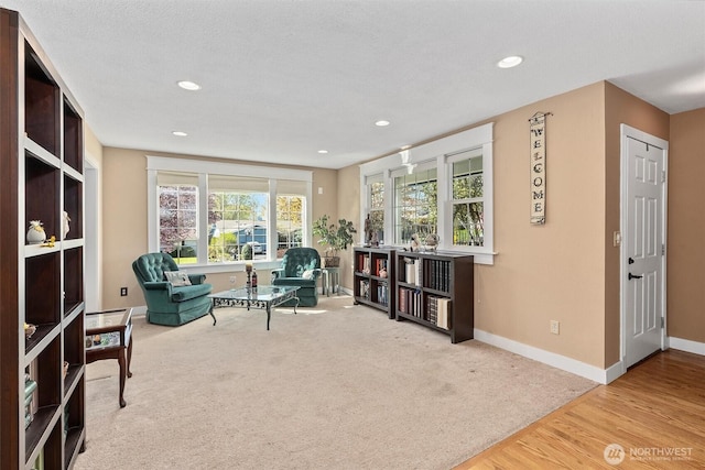 living area featuring carpet, wood finished floors, baseboards, and recessed lighting