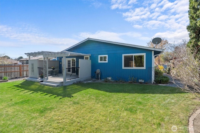 rear view of property featuring fence, a pergola, a lawn, and a wooden deck