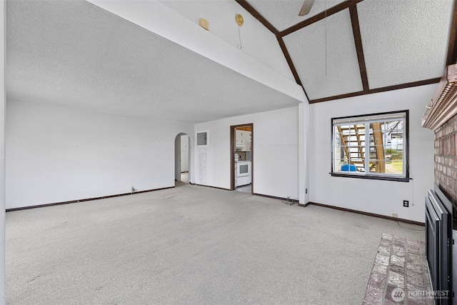 5323 Hyada Blvd NE, Tacoma, WA 98422 - unfurnished living room featuring ceiling fan, arched walkways, a fireplace, baseboards, and carpet