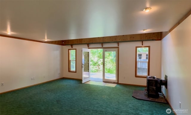 500 N Duckabush Dr W, Hoodsport, WA 98548 - unfurnished living room featuring a wood stove, carpet flooring, and baseboards