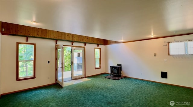 500 N Duckabush Dr W, Hoodsport, WA 98548 - unfurnished room with carpet, a wood stove, healthy amount of natural light, and baseboards