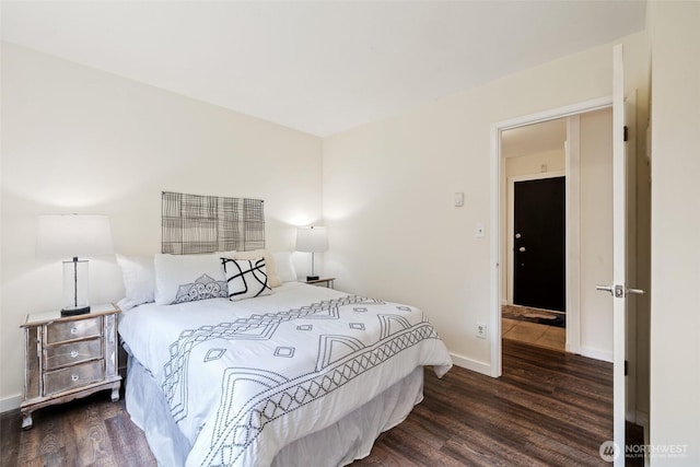 bedroom featuring wood finished floors and baseboards