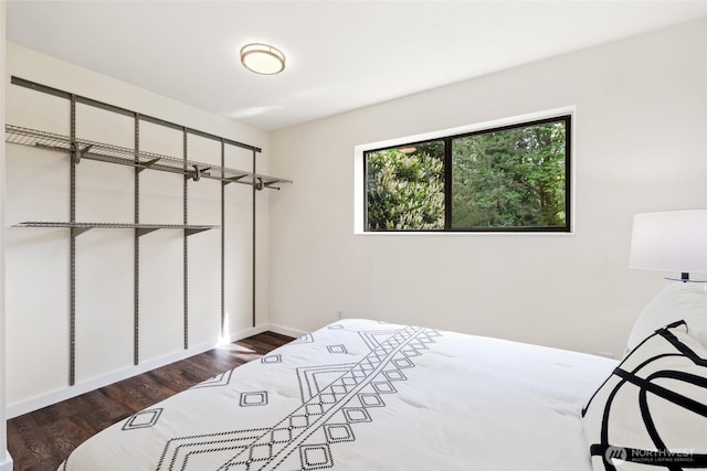 bedroom featuring wood finished floors and baseboards