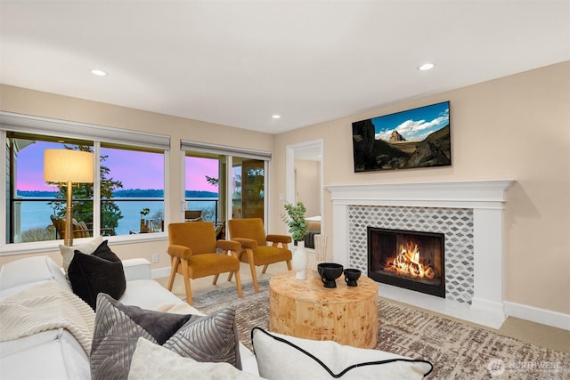 living room with recessed lighting, a tiled fireplace, and baseboards